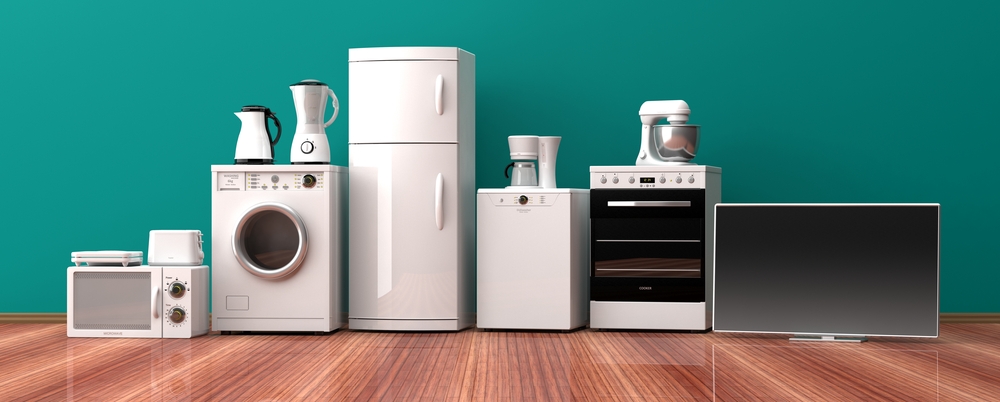 Most major household appliances (refrigerator, oven, microwave, washing machine, TV, laptop, printer, TV, toaster, coffemaker) artfully arranged in living room.