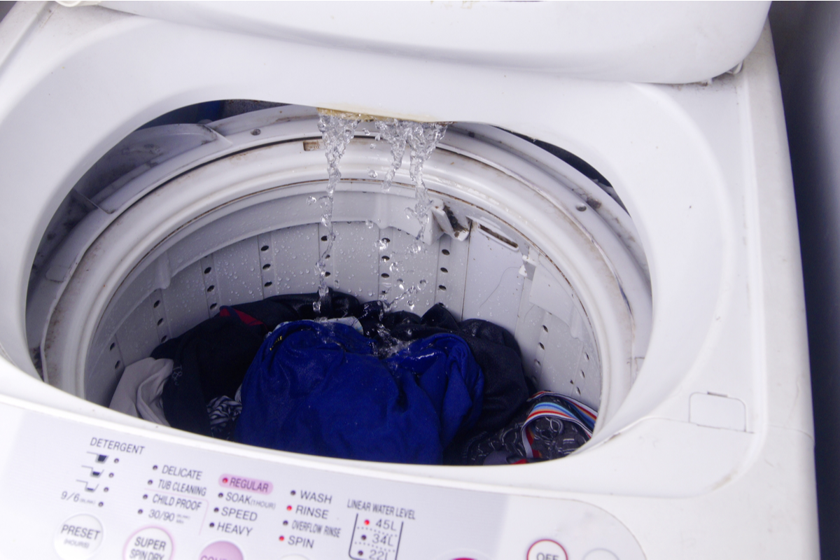 Washing machine drum full of water and dirty laundry.