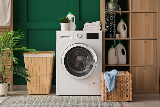 Washing machine in laundry room with hamper.