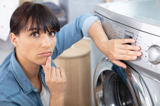 Woman thinking why washer is shaking violently.