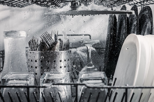 Dishwasher loaded with dishes that are getting washed.